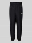 EA7 Emporio Armani Tapered Fit Trackpants mit Label-Print in Black, Gr...